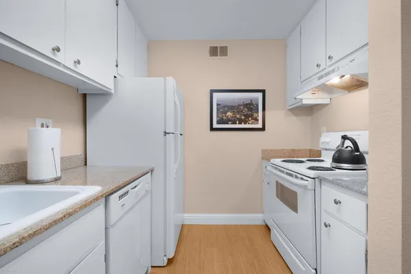 a kitchen with cabinets and wooden floor