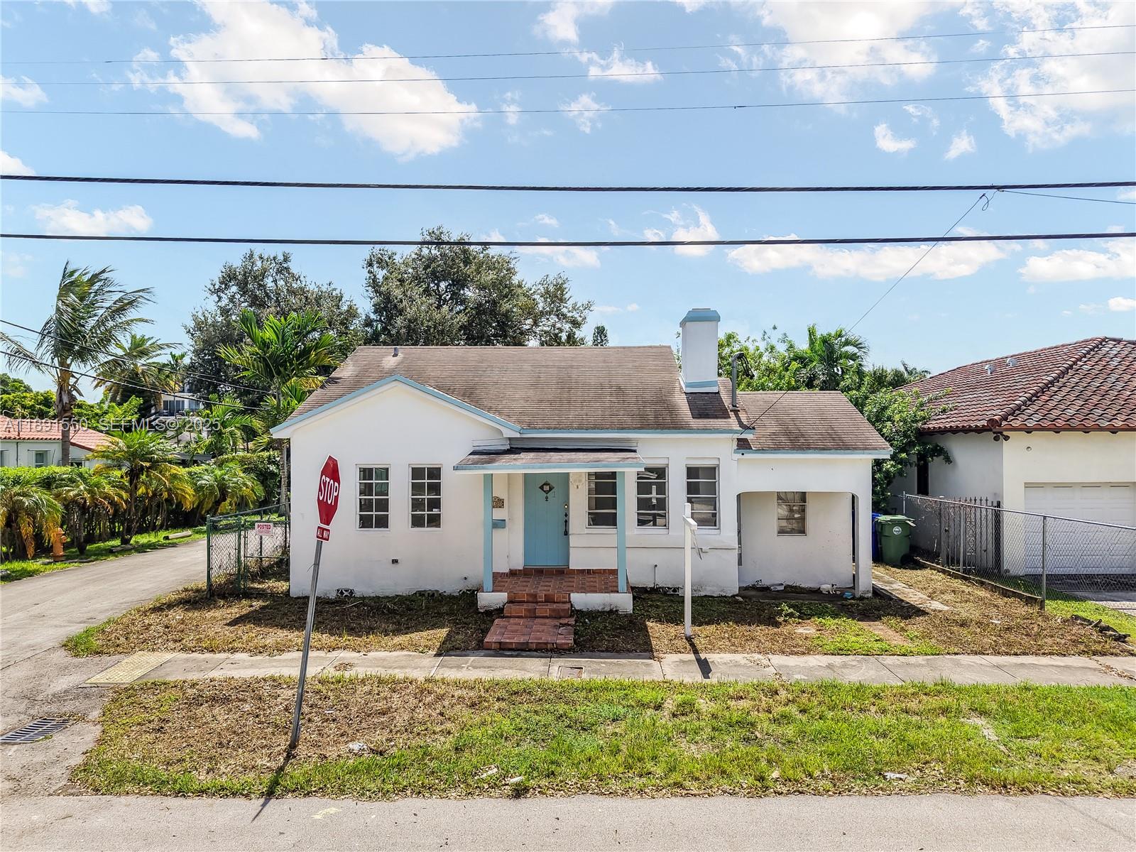 2100 Southwest 25th Street Miami, FL 33133 - Photo 2 of 23 a view of a white house with a big yard and large tree