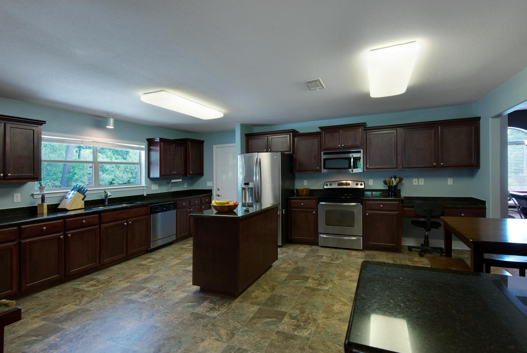 2383 Crescent Road Navarre, FL 32566 - Photo 12 of 48 a kitchen with stainless steel appliances granite countertop a stove top oven a sink dishwasher a dining table and chairs with wooden floor