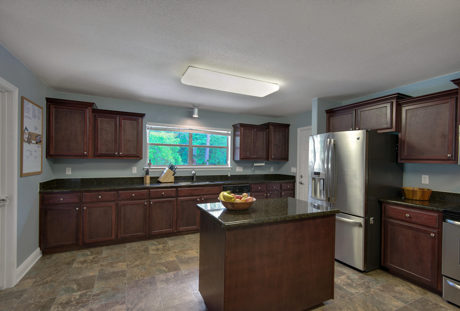 2383 Crescent Road Navarre, FL 32566 - Photo 13 of 48 a kitchen with stainless steel appliances granite countertop a refrigerator a sink a stove a microwave and wooden cabinets