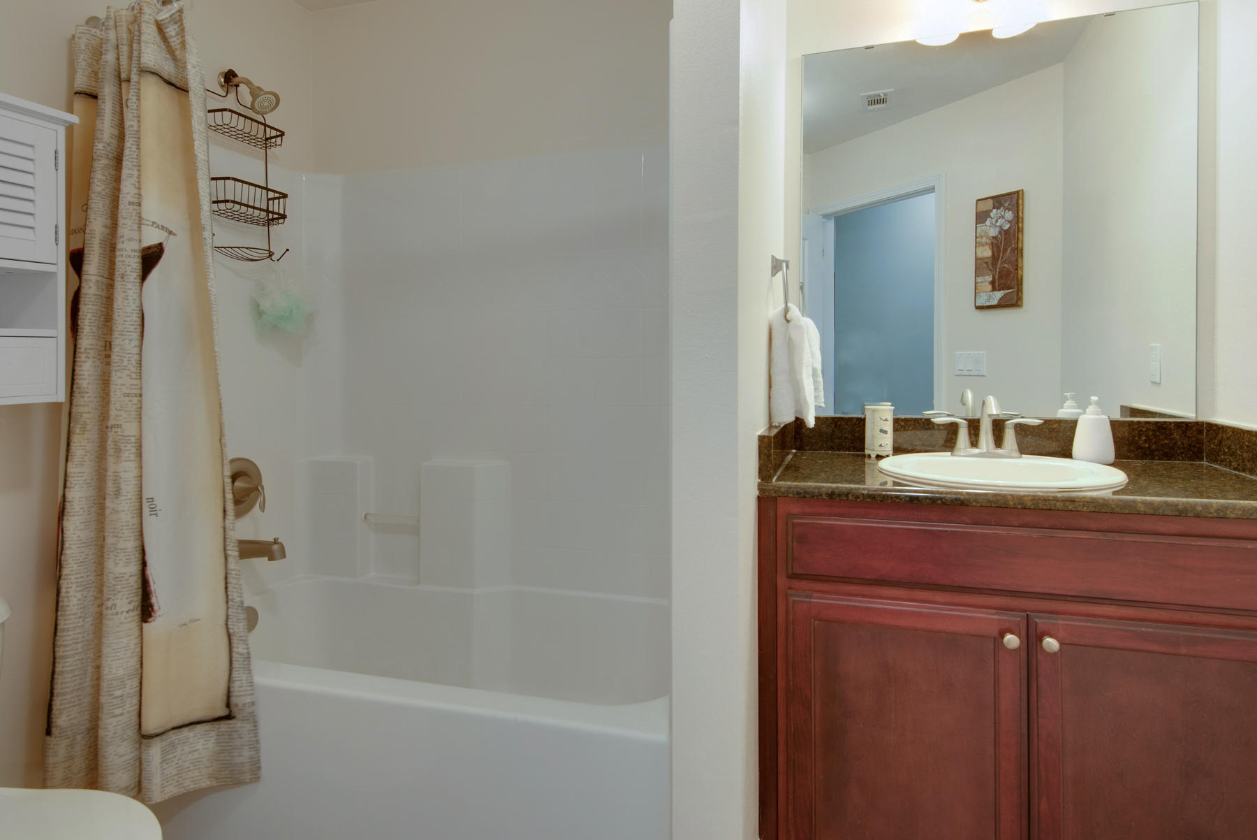 2383 Crescent Road Navarre, FL 32566 - Photo 24 of 48 a bathroom with a granite countertop sink a mirror and a bathtub