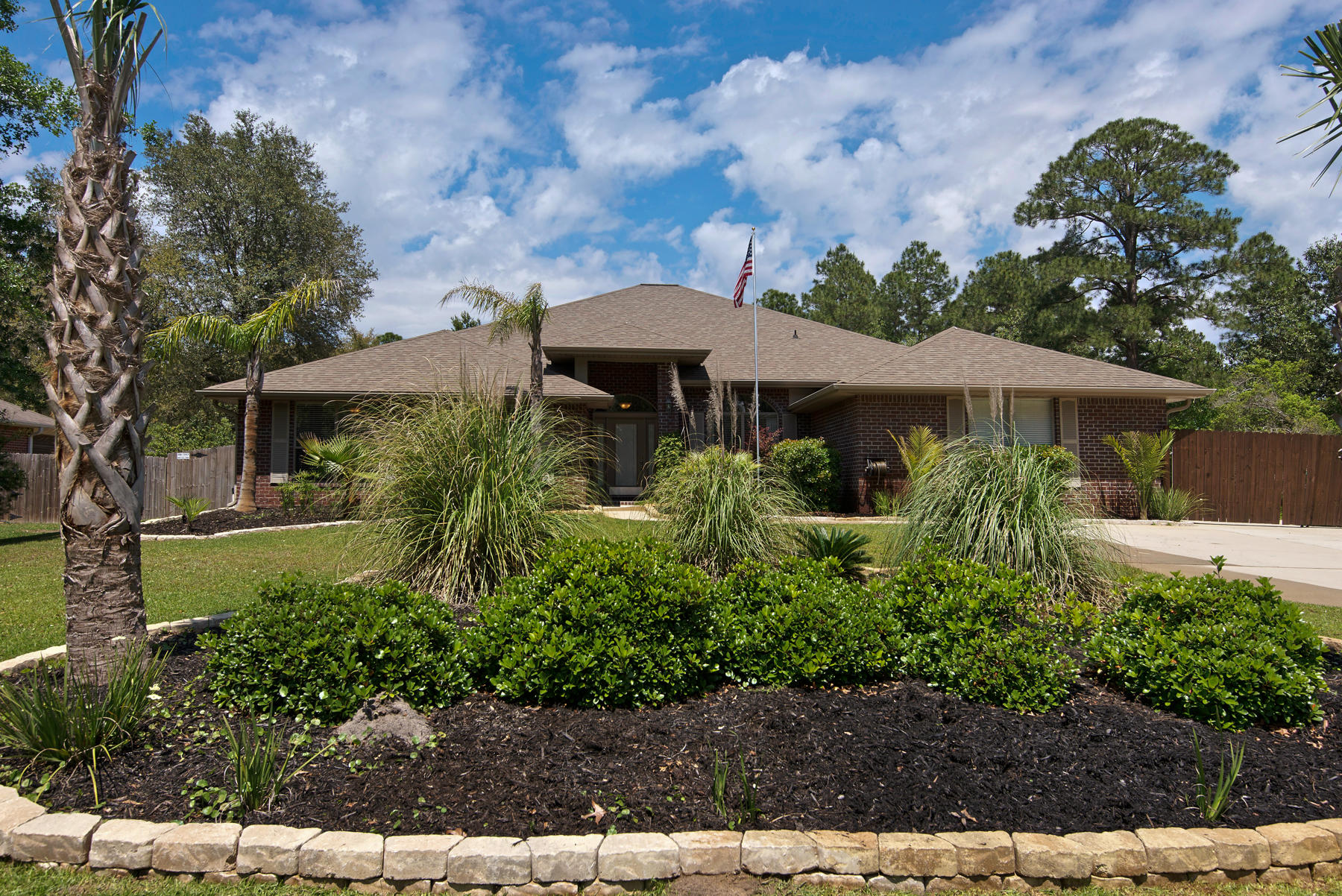 2383 Crescent Road Navarre, FL 32566 - Photo 48 of 48 a view of a garden with a table and chairs under an umbrella