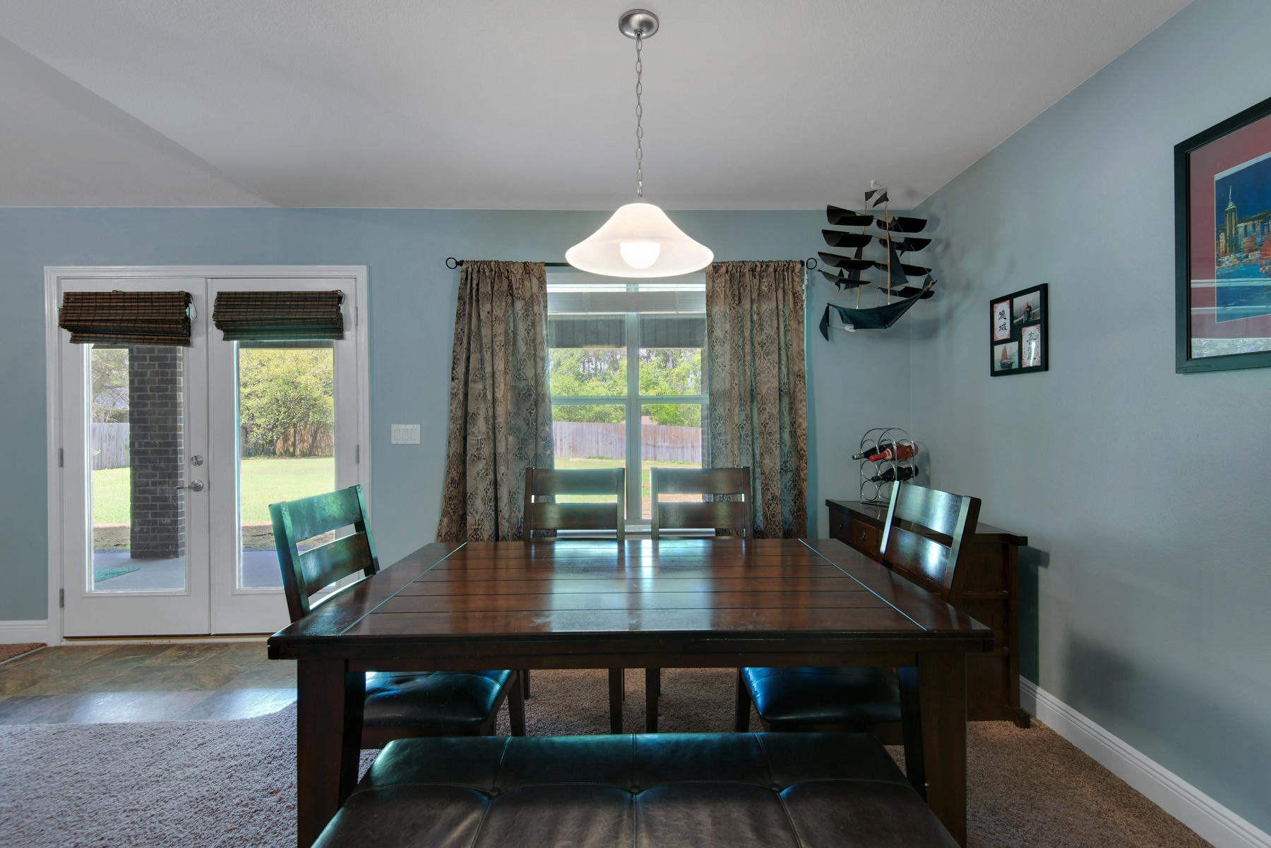 2383 Crescent Road Navarre, FL 32566 - Photo 10 of 48 a dining room with wooden floor a chandelier a wooden table and chairs