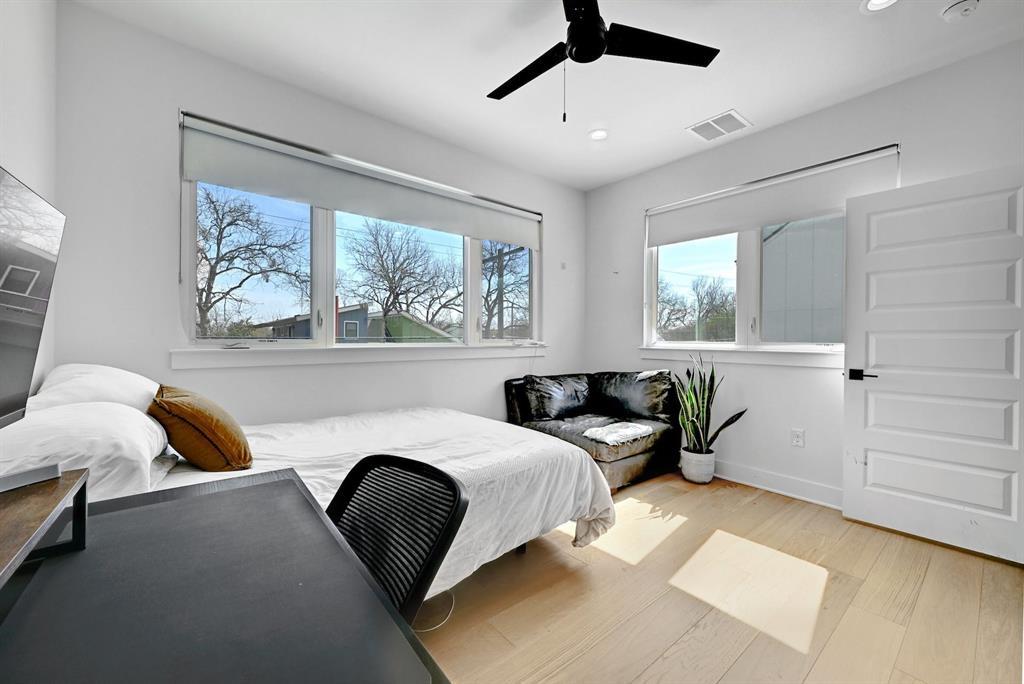 2812 East 4th Street, Unit 2 Austin, TX 78702 - Photo 18 of 26 Bright room featuring light wood-finish flooring, white walls, and multiple windows with roller shades