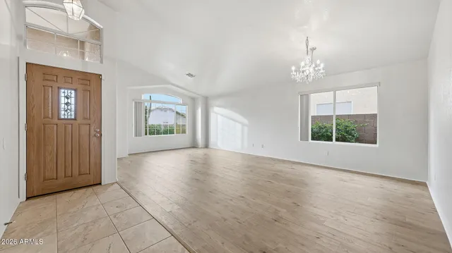 an empty room with windows and chandelier
