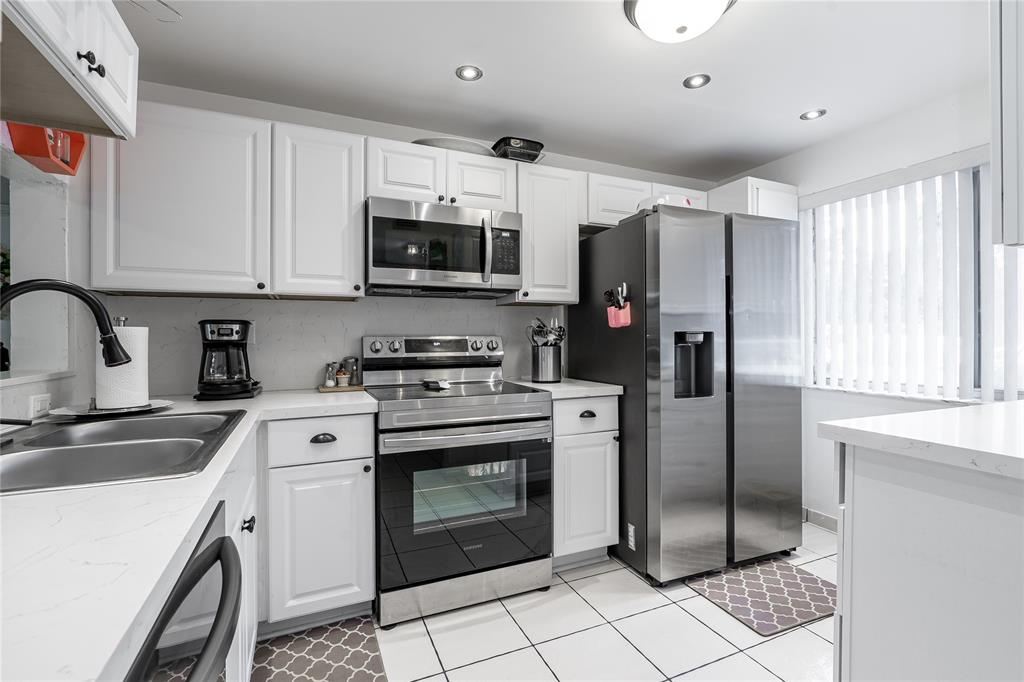 a kitchen with stainless steel appliances granite countertop a refrigerator a sink a stove a microwave and island