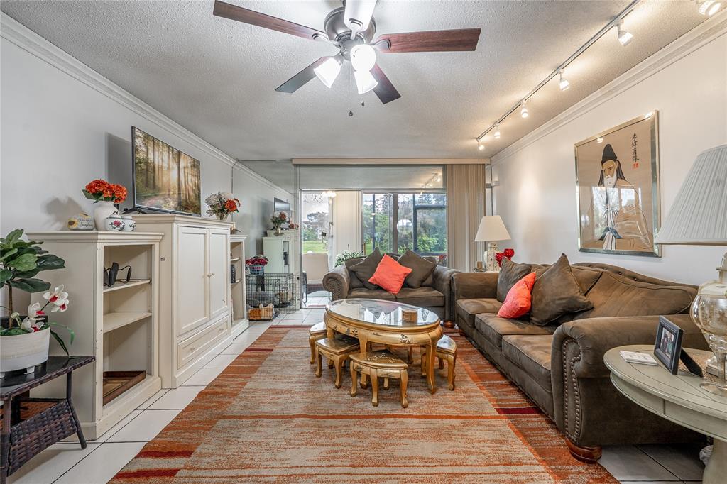 3601 Inverrary Drive, Unit 107 Lauderhill, FL 33319 - Photo 8 of 25 a living room with furniture fireplace and a chandelier