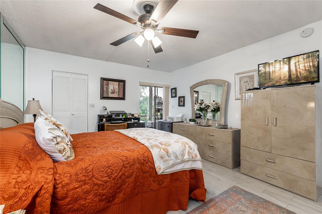 3601 Inverrary Drive, Unit 107 Lauderhill, FL 33319 - Photo 10 of 25 a bedroom with a large bed and a chandelier