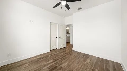 a view of an empty room with wooden floor
