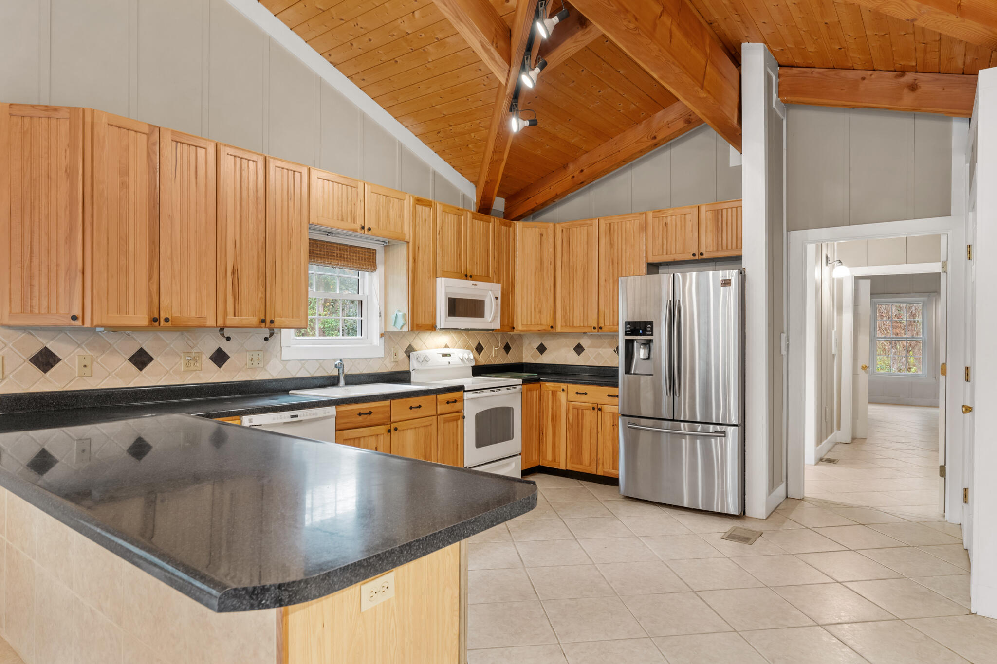 108 Osprey Lane Santa Rosa Beach, FL 32459 - Photo 7 of 40 a kitchen with stainless steel appliances granite countertop a refrigerator a sink dishwasher a stove with white cabinets and countertops
