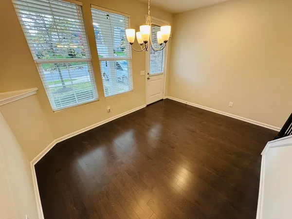 a view of a room with wooden floor and windows