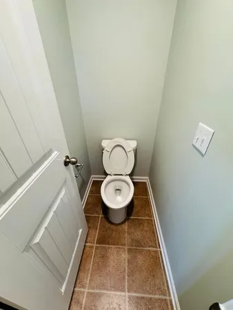 a bathroom with a toilet and a rug