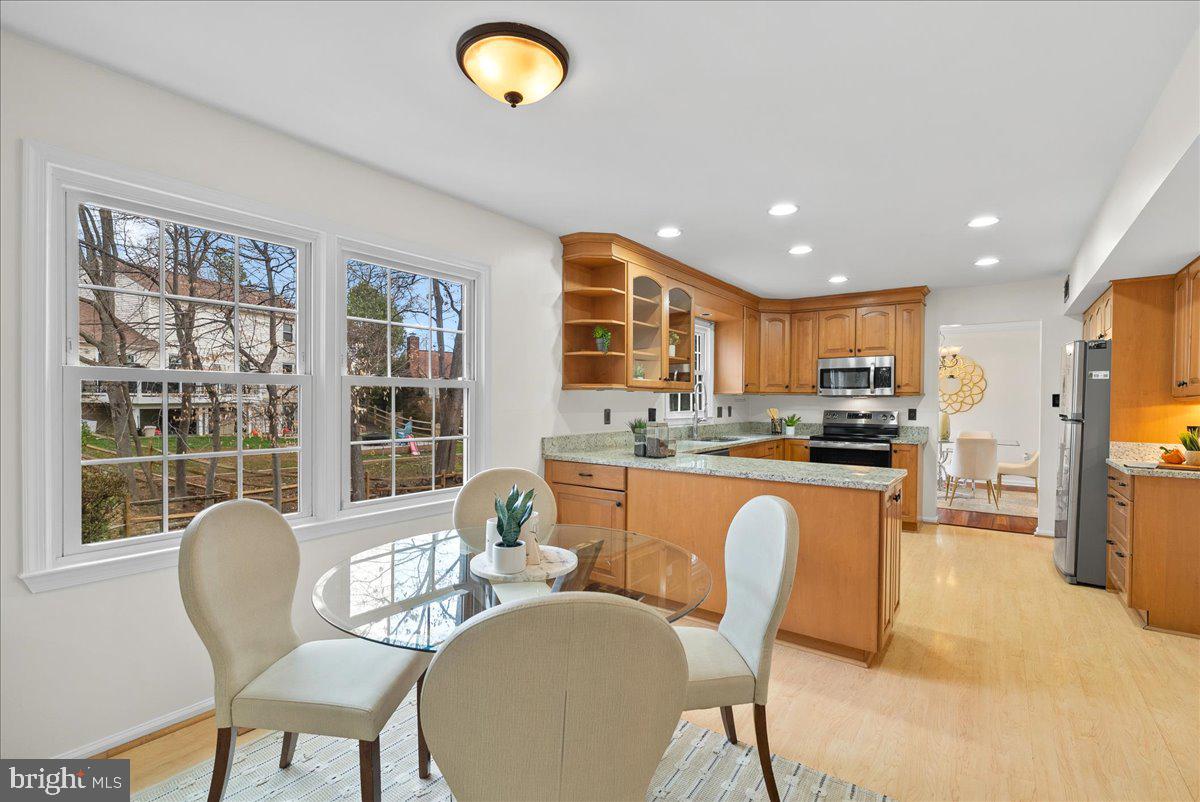7596 Ruxton Drive Springfield, VA 22153 - Photo 18 of 40 a kitchen with stainless steel appliances granite countertop a stove a refrigerator a kitchen island a table and chairs