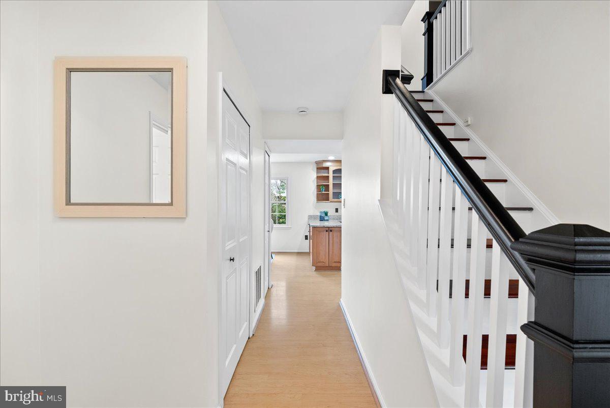 7596 Ruxton Drive Springfield, VA 22153 - Photo 19 of 40 a view of a hallway with wooden floor and staircase