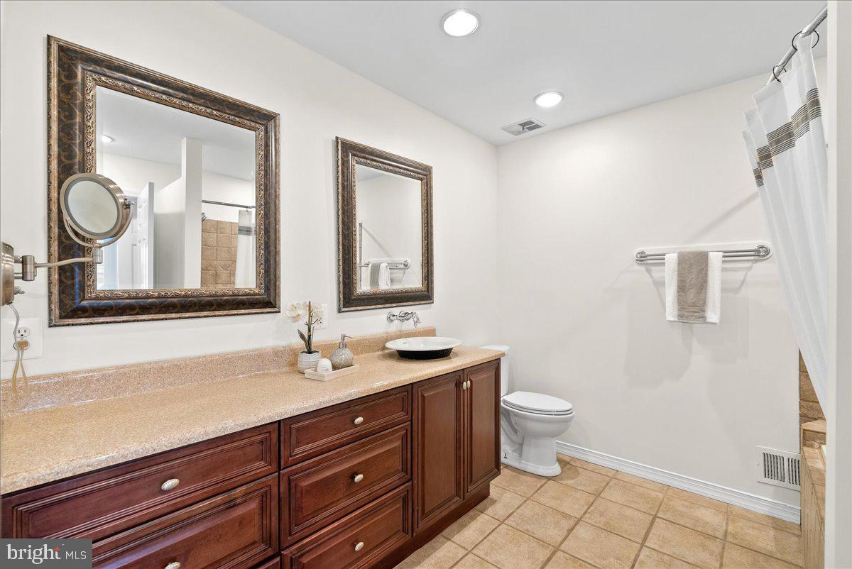 7596 Ruxton Drive Springfield, VA 22153 - Photo 21 of 40 a bathroom with a granite countertop toilet sink and mirror