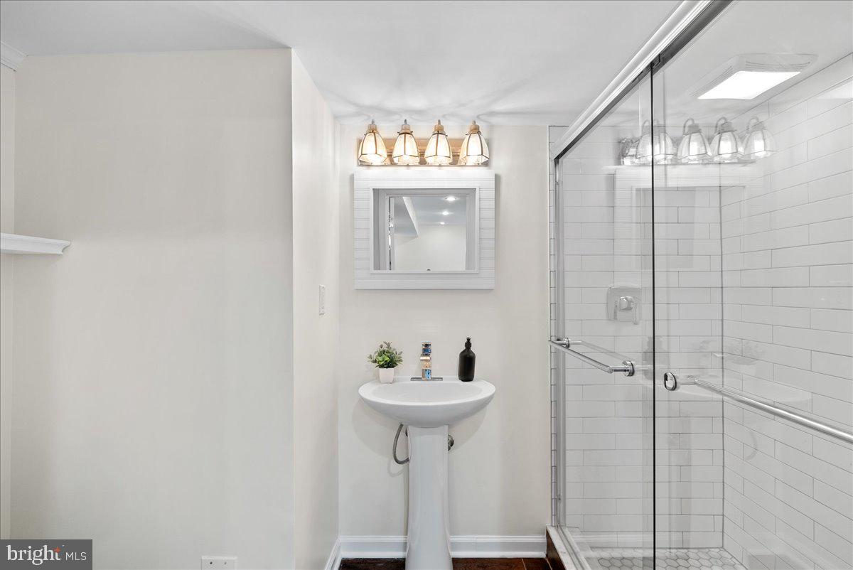 7596 Ruxton Drive Springfield, VA 22153 - Photo 32 of 40 a bathroom with a sink a mirror and a shower