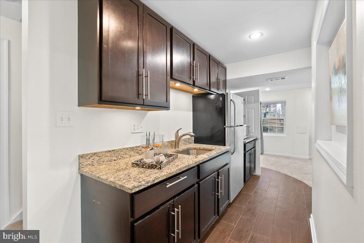 7596 Ruxton Drive Springfield, VA 22153 - Photo 35 of 40 a kitchen with stainless steel appliances granite countertop cabinets and refrigerator