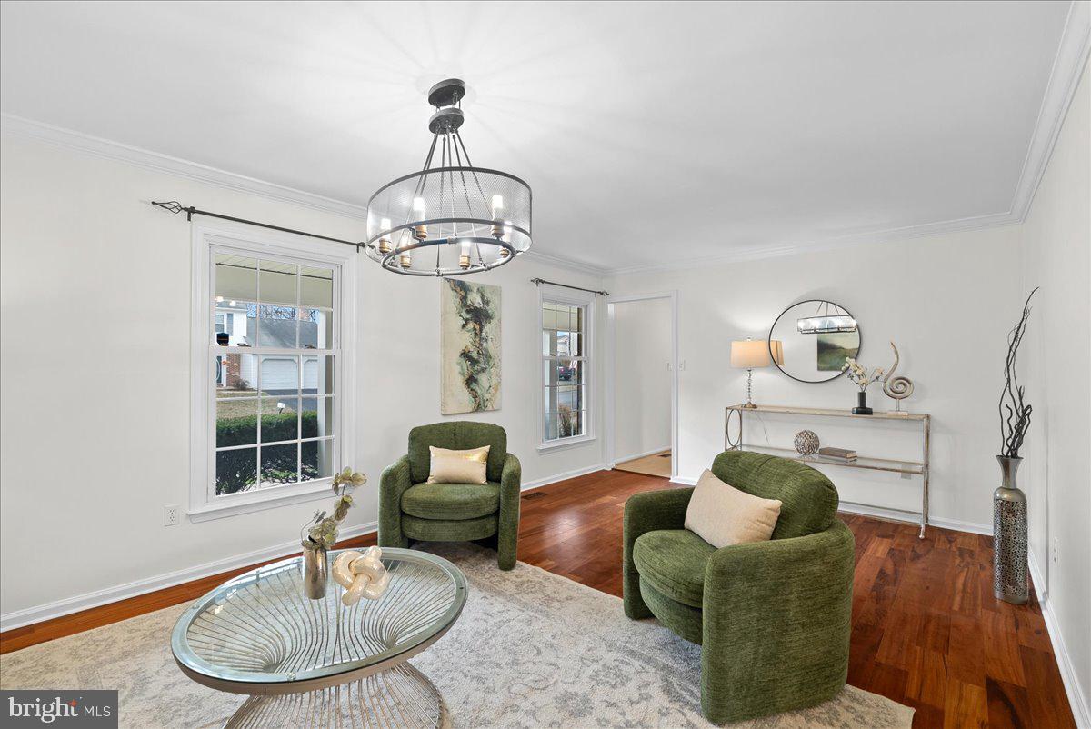 7596 Ruxton Drive Springfield, VA 22153 - Photo 10 of 40 a living room with furniture a chandelier and a fireplace