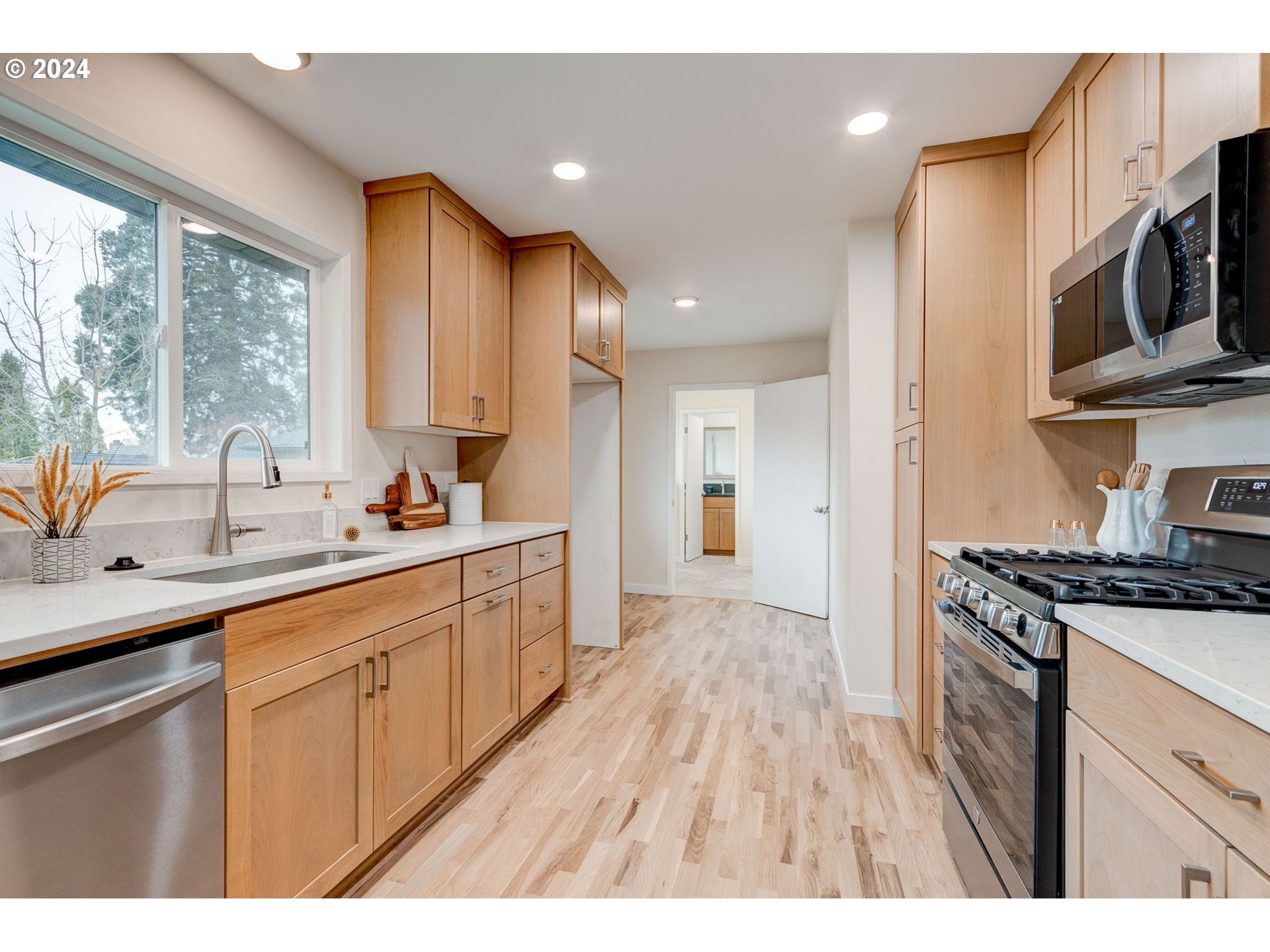 8815 Southwest 69th Avenue Portland, OR 97223 - Photo 11 of 36 a kitchen with stainless steel appliances a sink stove and cabinets