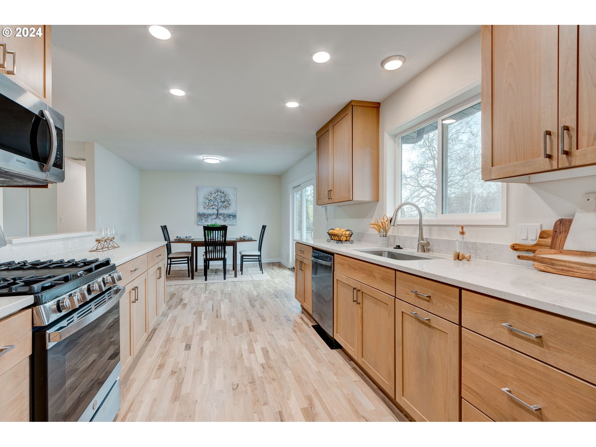 8815 Southwest 69th Avenue Portland, OR 97223 - Photo 12 of 36 a kitchen with stainless steel appliances granite countertop a stove a sink dishwasher and a microwave with wooden floor
