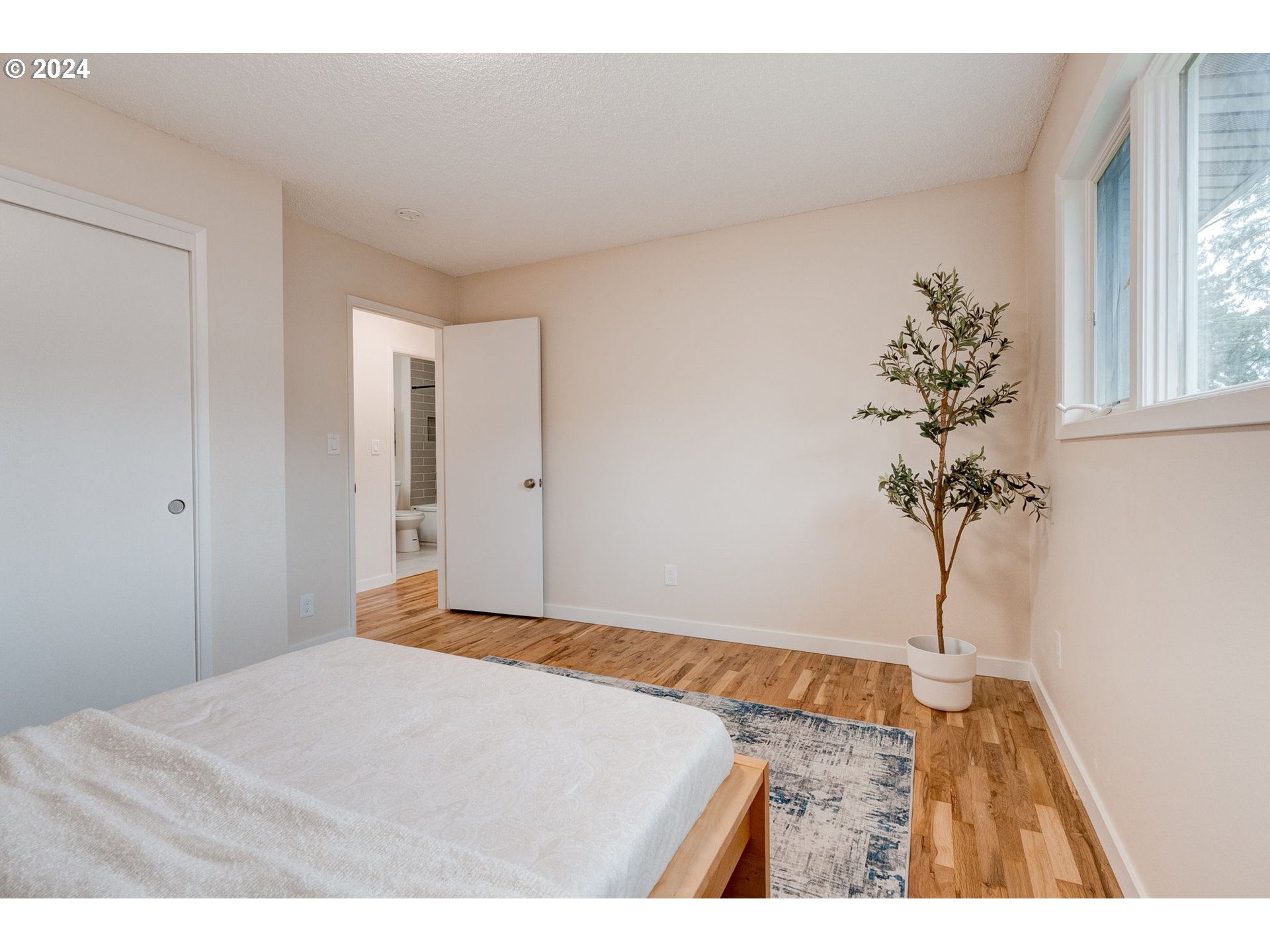 8815 Southwest 69th Avenue Portland, OR 97223 - Photo 15 of 36 a bedroom with a bed and a potted plant
