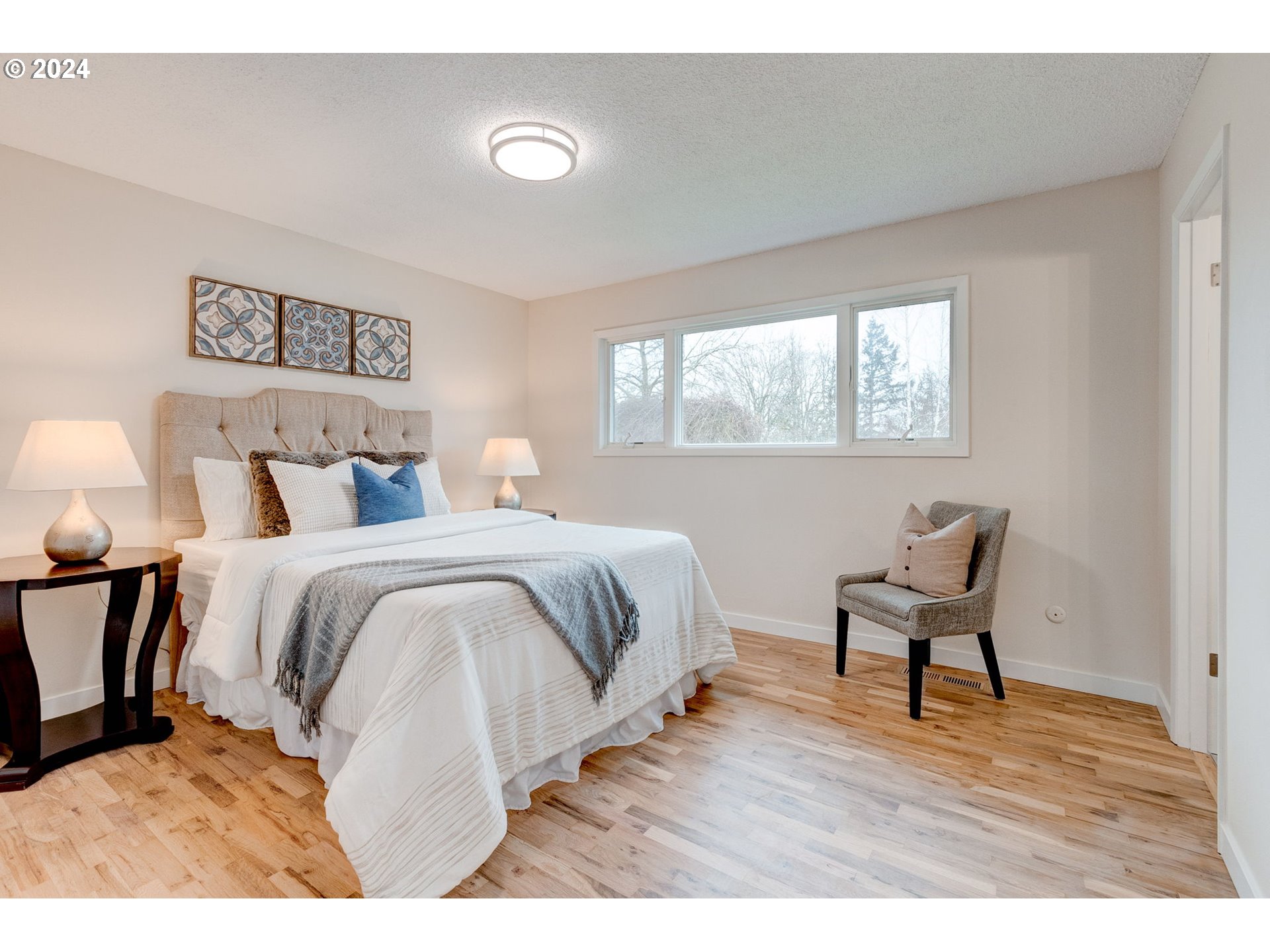 8815 Southwest 69th Avenue Portland, OR 97223 - Photo 19 of 36 a bedroom with a bed and a chair