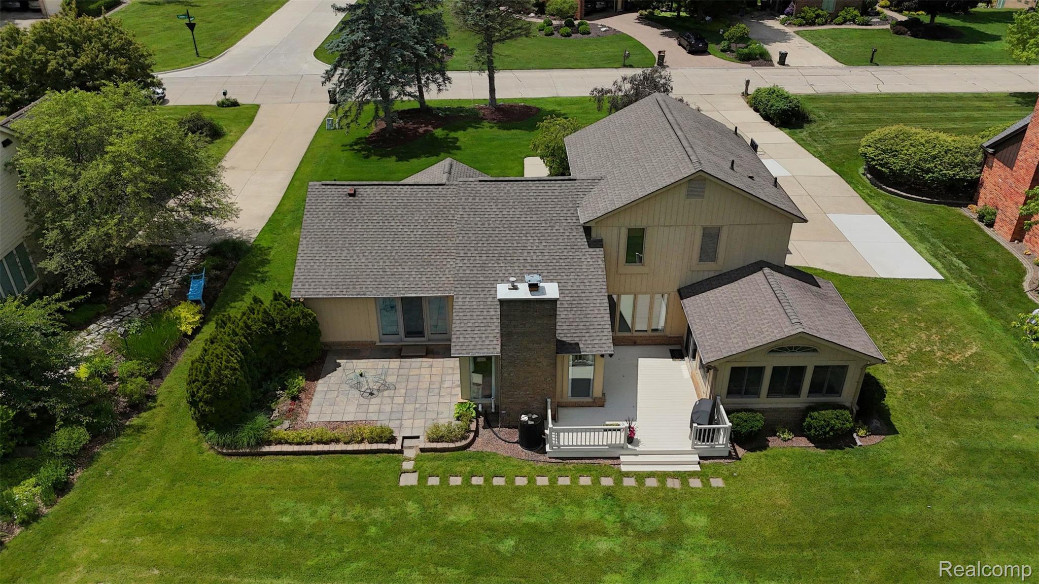 1236 Chaffer Drive Rochester, MI 48306 - Photo 73 of 76 Rear exterior featuring a paver patio, stone chimney, sunroom extension, and a composite deck with white railings