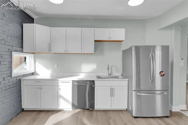 a kitchen with appliances a sink and a refrigerator