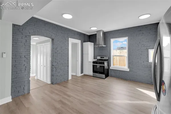 a view of empty room with a kitchen and windows
