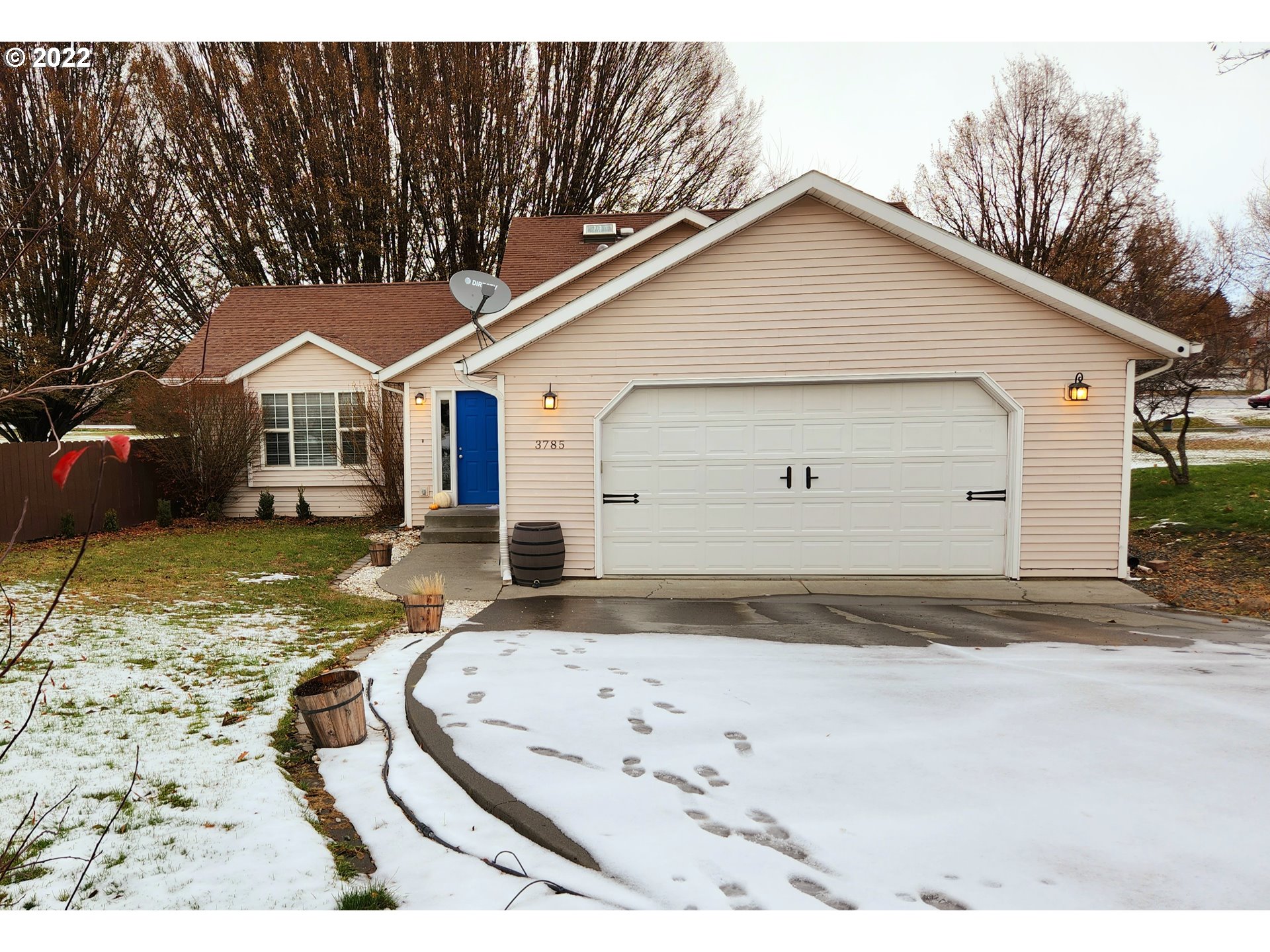 a view of a white house with a large yard and large tree