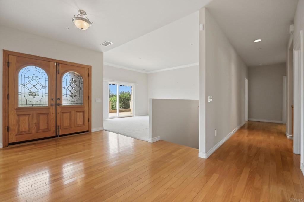 2596 Green Canyon Road Fallbrook, CA 92028 - Photo 4 of 74 an empty room with wooden floor cabinet and windows