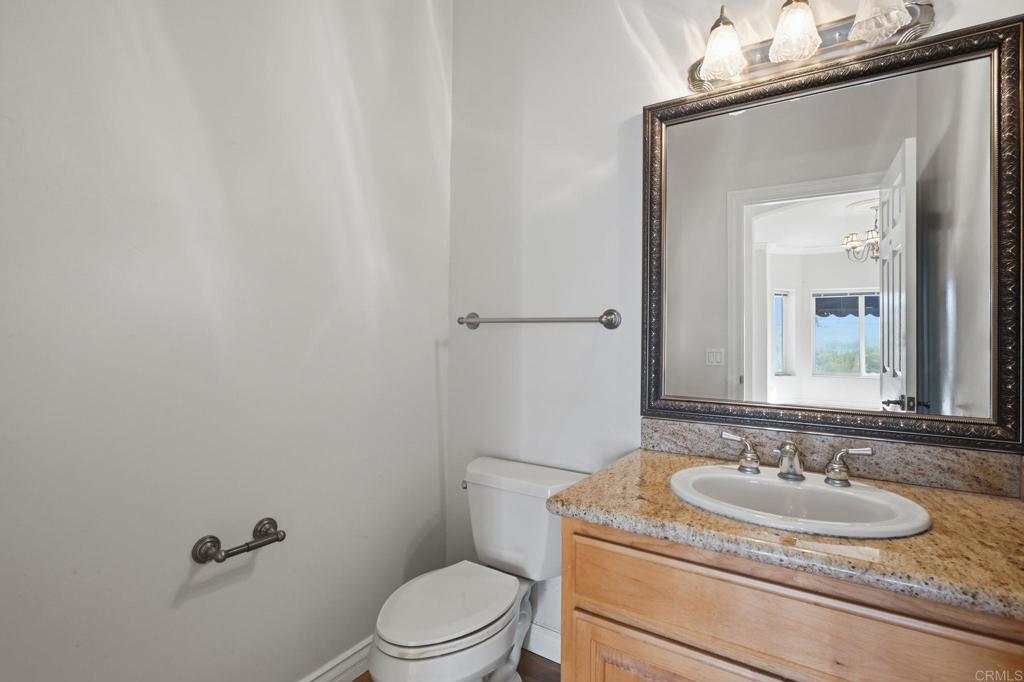 2596 Green Canyon Road Fallbrook, CA 92028 - Photo 47 of 74 a bathroom with a granite countertop sink a toilet and mirror