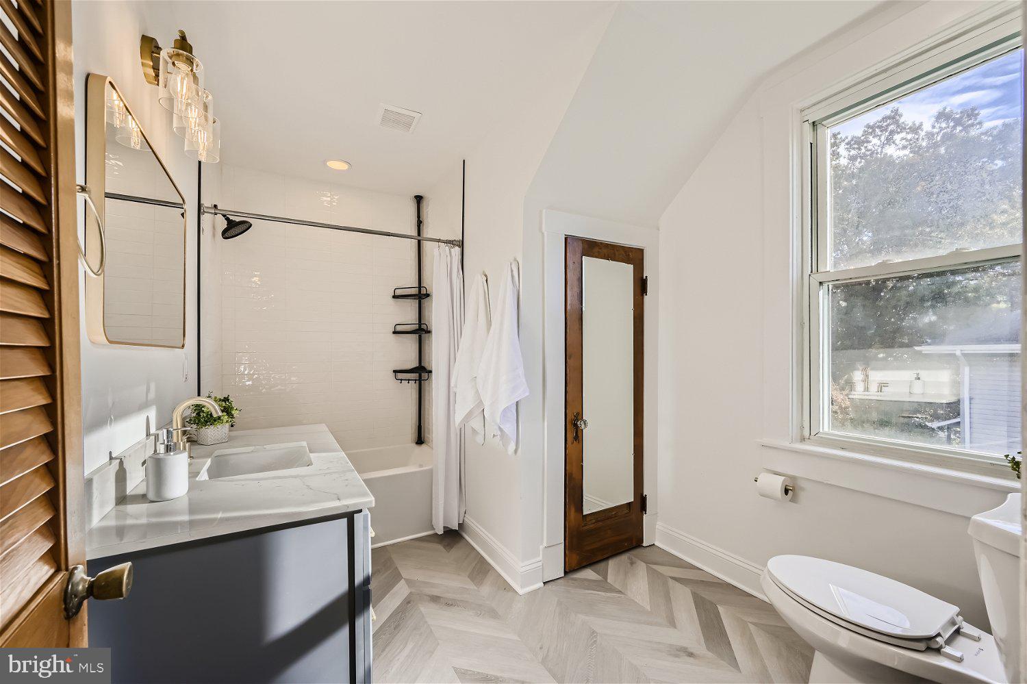 611 Coleraine Road Baltimore, MD 21229 - Photo 28 of 33 a bathroom with a granite countertop sink toilet a mirror and shower