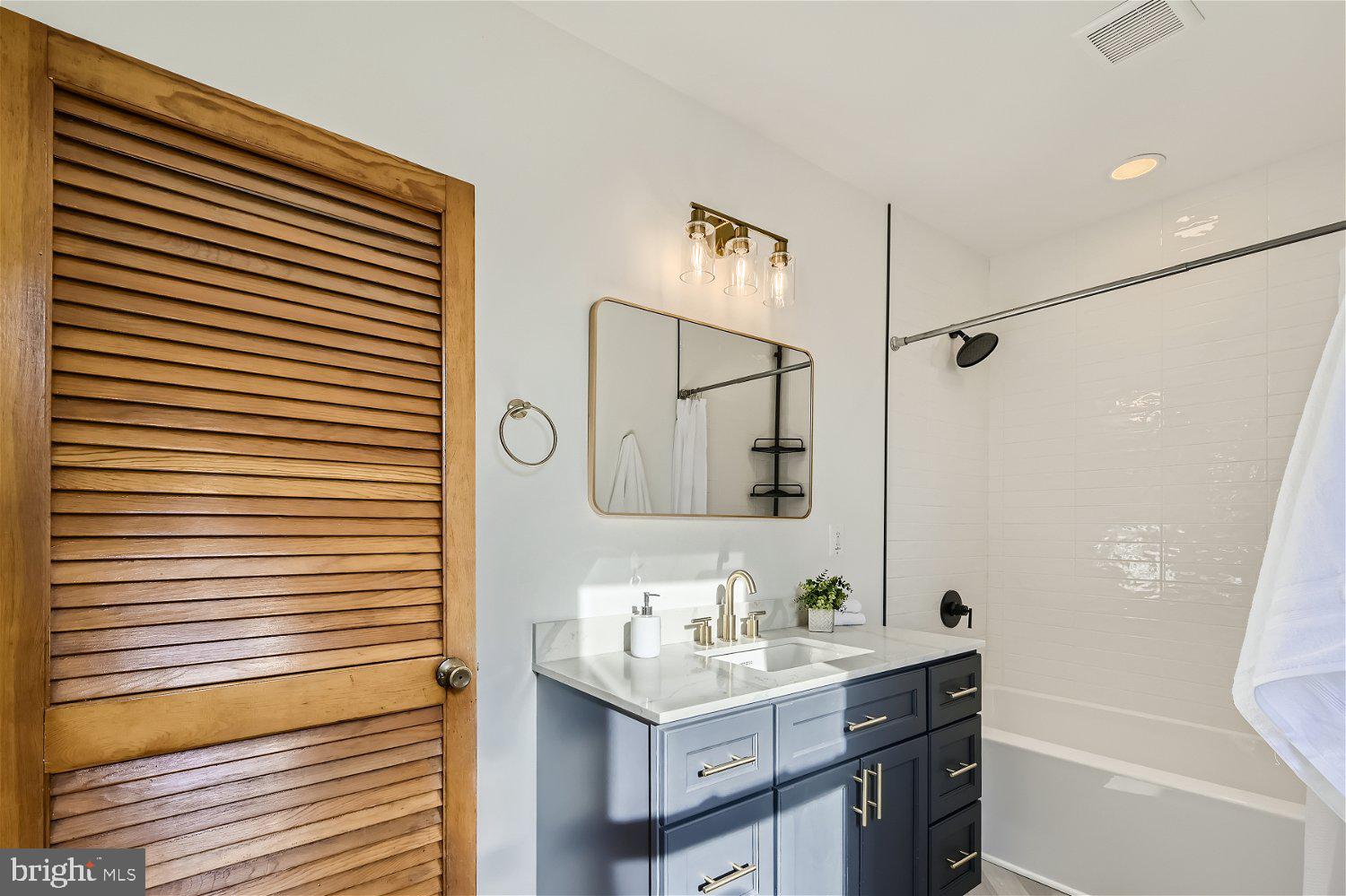 611 Coleraine Road Baltimore, MD 21229 - Photo 29 of 33 a bathroom with a sink a mirror and a shower