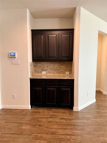 a view of kitchen with granite countertop cabinets and a wooden floor