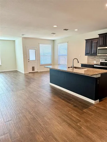 a view of kitchen with wooden floor and electronic appliances