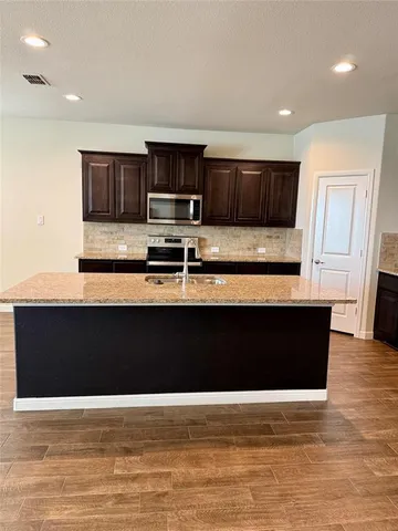 a black and white kitchen with wooden floor