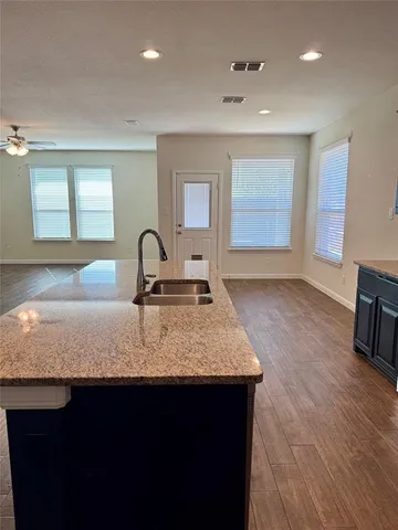 a kitchen with granite countertop a sink and cabinets