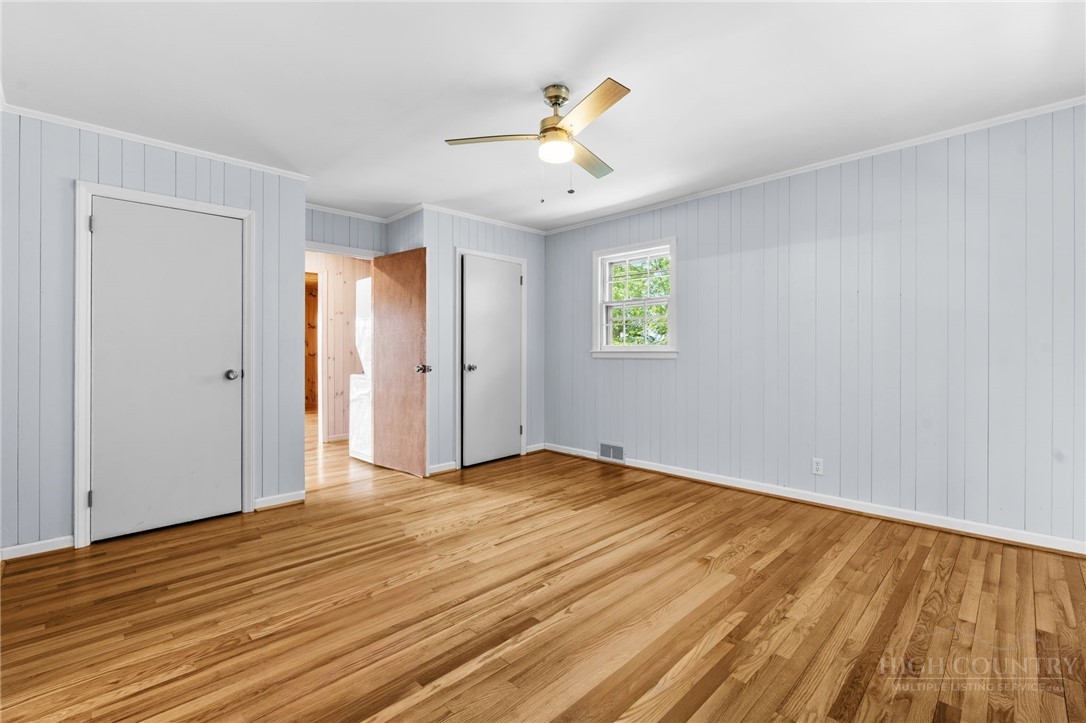 656 Goforth Road Blowing Rock, NC 28605 - Photo 14 of 36 an empty room with wooden floor ceiling fan and windows