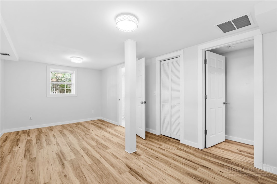 656 Goforth Road Blowing Rock, NC 28605 - Photo 21 of 36 an empty room with wooden floor and windows
