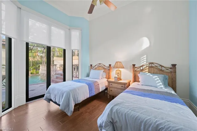 a bedroom with two beds and large windows