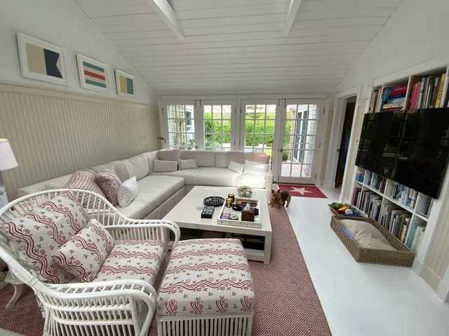 a living room with furniture a flat screen tv and a large window