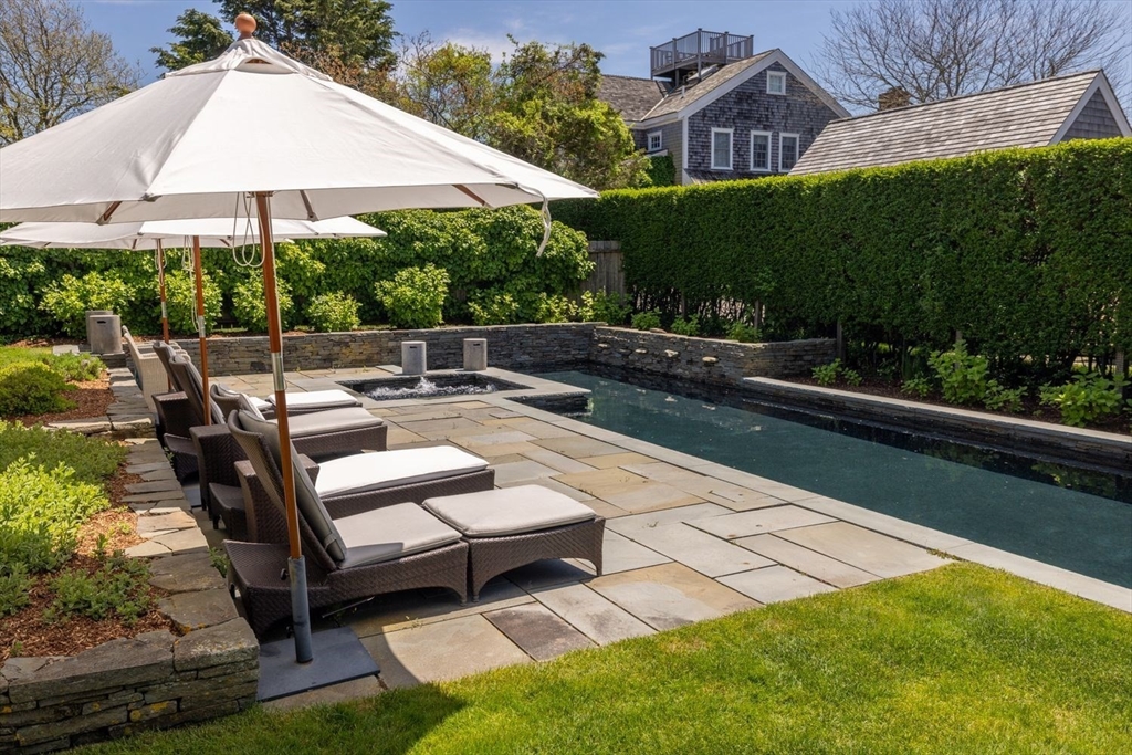 17 Burnell Street Nantucket, MA 02554 - Photo 2 of 24 a view of a patio with couches table and chairs under an umbrella