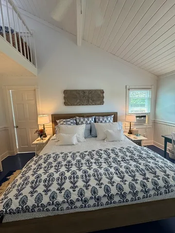 a large bed sitting in a bedroom next to a window