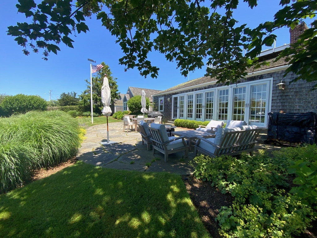 17 Burnell Street Nantucket, MA 02554 - Photo 3 of 24 a view of a patio with table and chairs potted plants and large tree