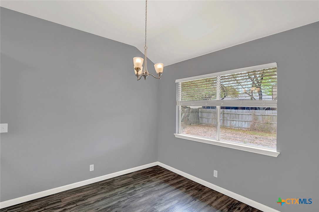 140 Riley Cove Kyle, TX 78640 - Photo 9 of 26 a view of an empty room with wooden floor and a window