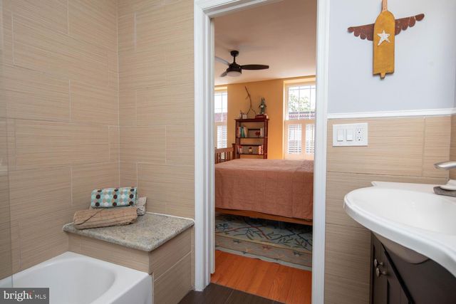 a en suite bathroom with a granite countertop sink and a mirror