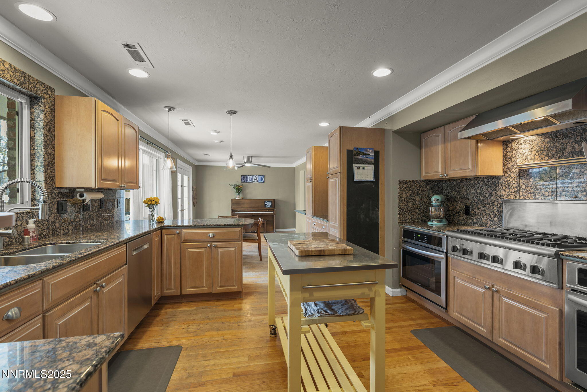 2260 Sunrise Drive Reno, NV 89509 - Photo 13 of 44 a kitchen with stainless steel appliances granite countertop a stove top oven a sink dishwasher a dining table and chairs with wooden floor