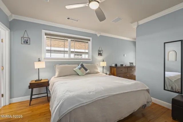 a bedroom with a bed chandelier and a window