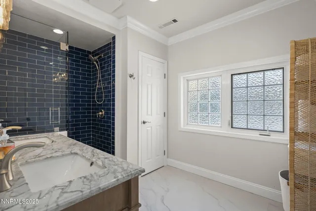 a bathroom with a granite countertop sink a toilet and window